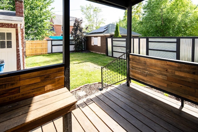 wooden terrace with a storage unit and a yard