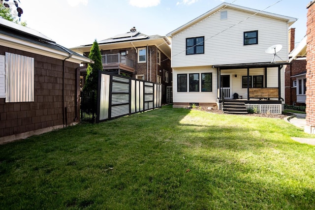 rear view of house featuring a lawn and a porch