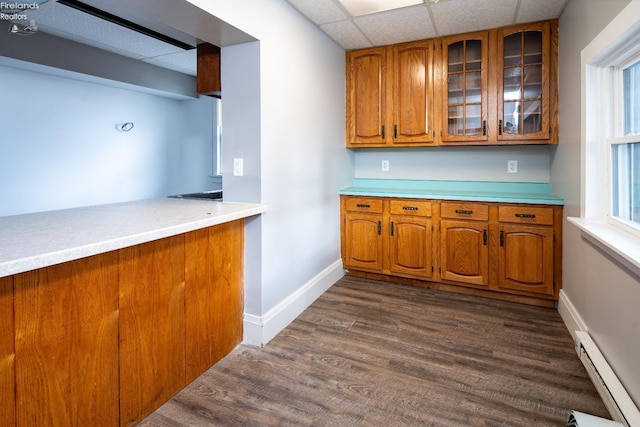 kitchen with a drop ceiling, dark hardwood / wood-style floors, and a baseboard radiator