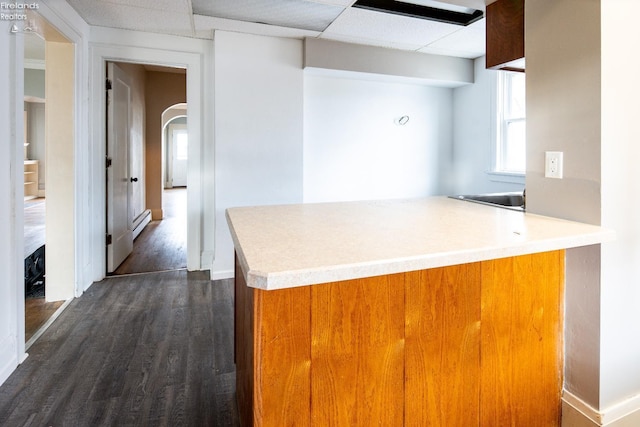 kitchen featuring a drop ceiling, dark wood-type flooring, and a baseboard radiator