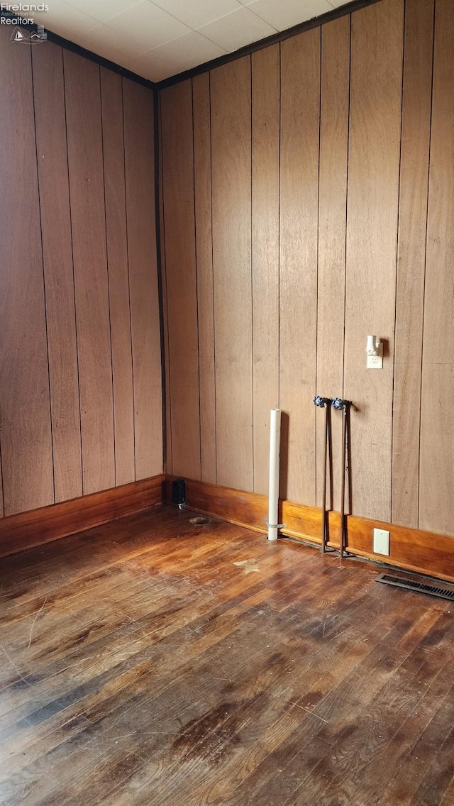 interior space featuring dark hardwood / wood-style flooring and wooden walls