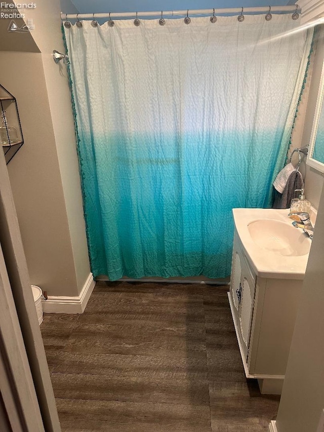 bathroom with vanity, wood-type flooring, and toilet