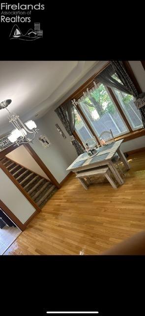 interior space featuring wood-type flooring and an inviting chandelier