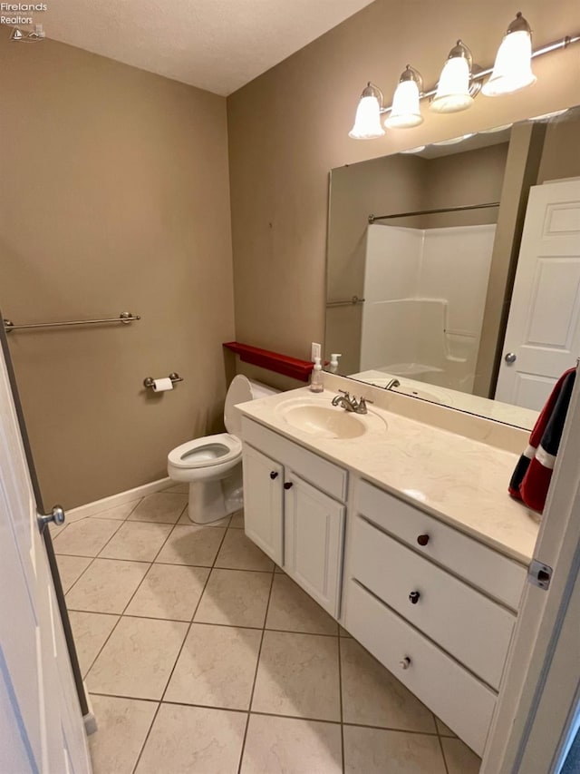 bathroom featuring a shower, vanity, tile patterned floors, and toilet