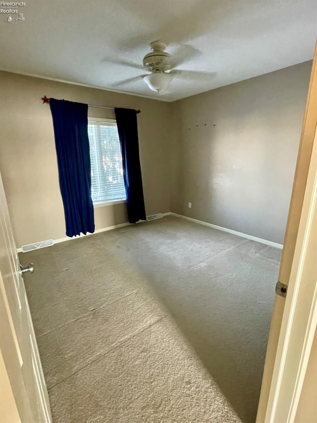 carpeted empty room featuring ceiling fan