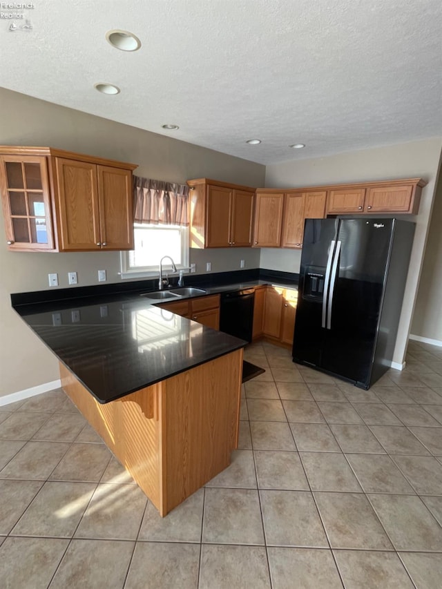 kitchen featuring black appliances, sink, light tile patterned flooring, a kitchen bar, and kitchen peninsula