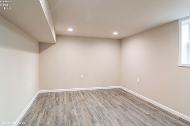 basement with light wood-type flooring and a wealth of natural light