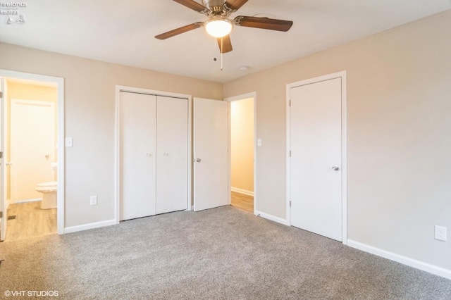 unfurnished bedroom featuring ensuite bath, ceiling fan, a closet, and light carpet