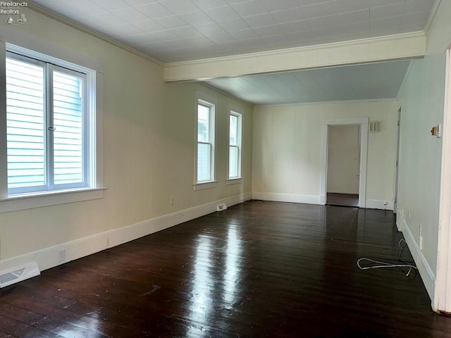 spare room featuring ornamental molding, a wealth of natural light, and dark wood-type flooring