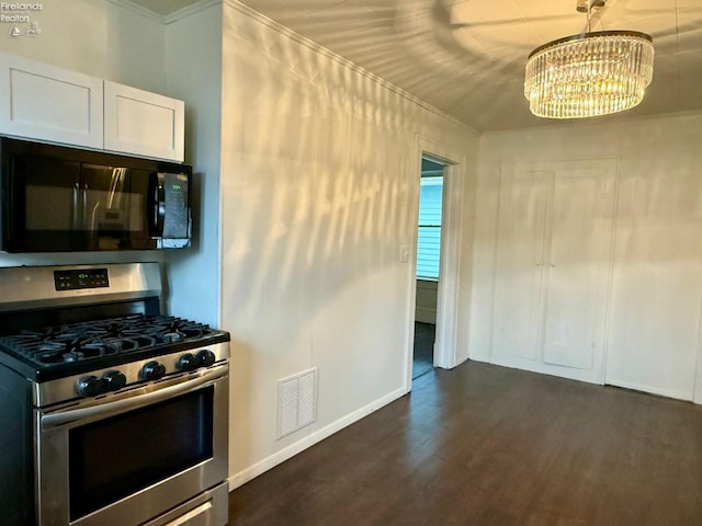 kitchen with crown molding, stainless steel gas stove, dark hardwood / wood-style floors, a notable chandelier, and white cabinetry