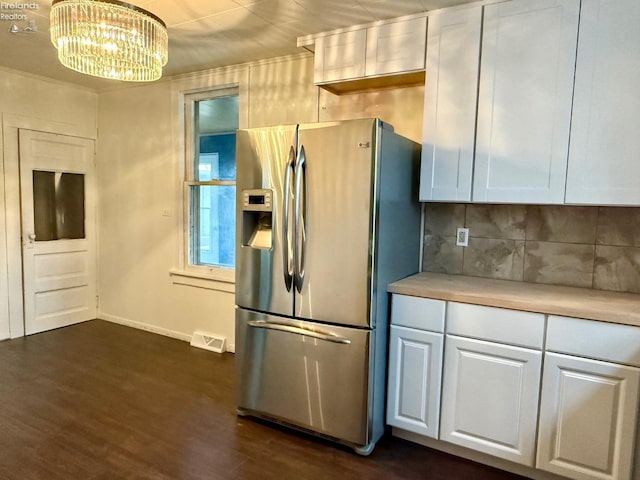 kitchen with stainless steel fridge, backsplash, decorative light fixtures, white cabinets, and dark hardwood / wood-style floors