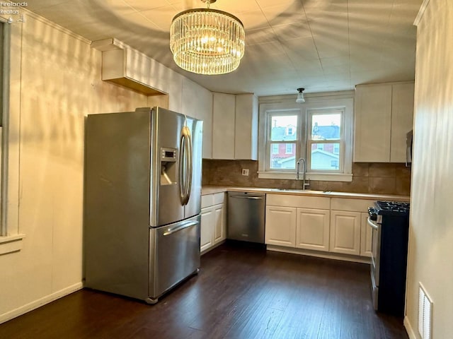 kitchen featuring dark hardwood / wood-style flooring, stainless steel appliances, sink, white cabinetry, and hanging light fixtures