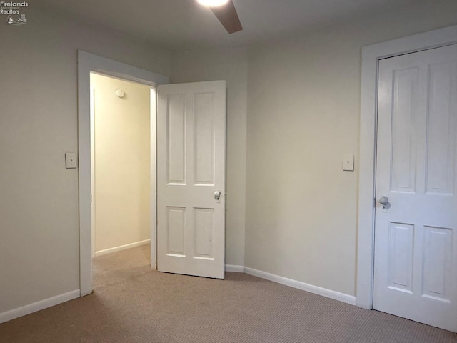 unfurnished bedroom with ceiling fan and light colored carpet