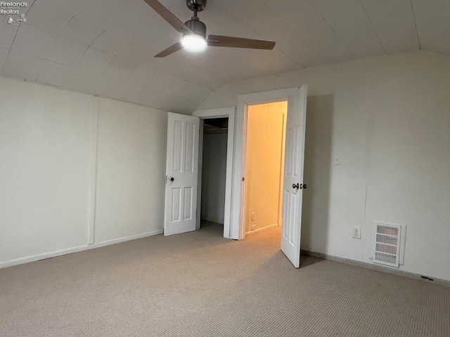 unfurnished bedroom with ceiling fan, light carpet, and vaulted ceiling