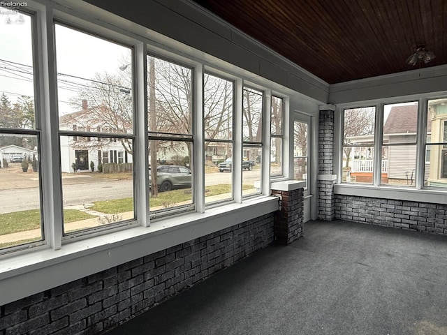 unfurnished sunroom with plenty of natural light and wood ceiling