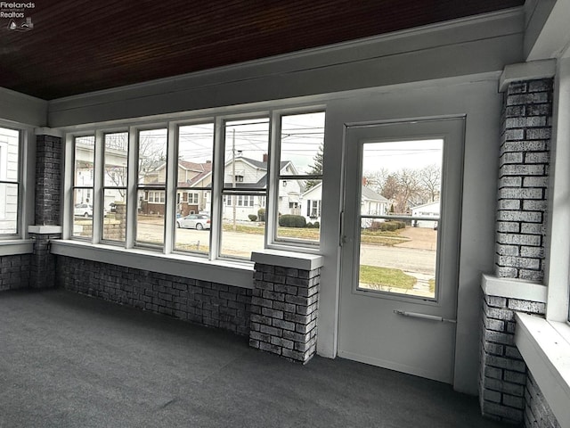 unfurnished sunroom with wood ceiling and a wealth of natural light