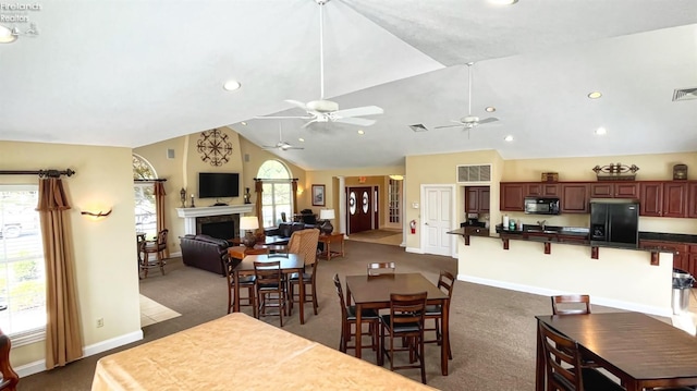 dining room with dark carpet, a wealth of natural light, and lofted ceiling