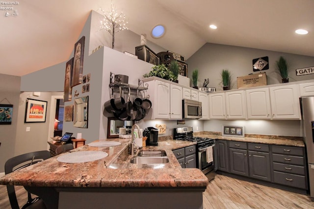 kitchen featuring stainless steel appliances, vaulted ceiling, sink, white cabinets, and gray cabinets