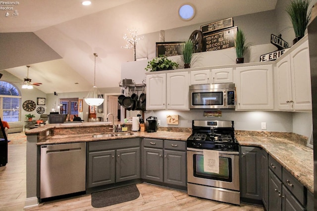 kitchen featuring white cabinetry, sink, vaulted ceiling, and appliances with stainless steel finishes