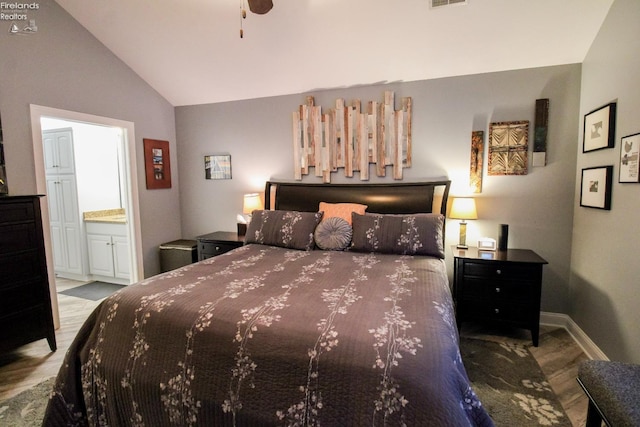 bedroom featuring lofted ceiling and ensuite bath