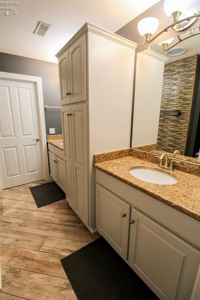 bathroom with a chandelier, hardwood / wood-style floors, and vanity