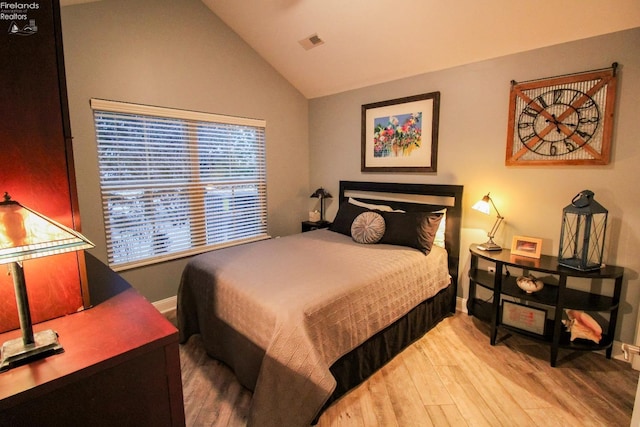 bedroom with light wood-type flooring and lofted ceiling