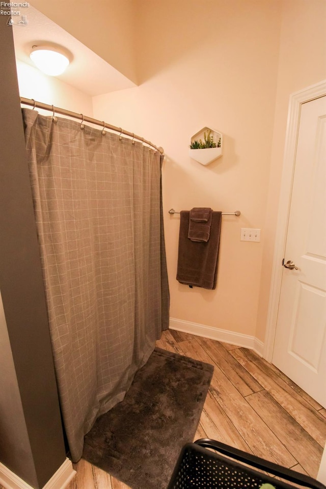 bathroom with hardwood / wood-style floors and curtained shower