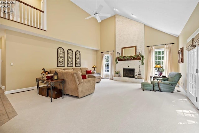 carpeted living room featuring high vaulted ceiling, a stone fireplace, and ceiling fan