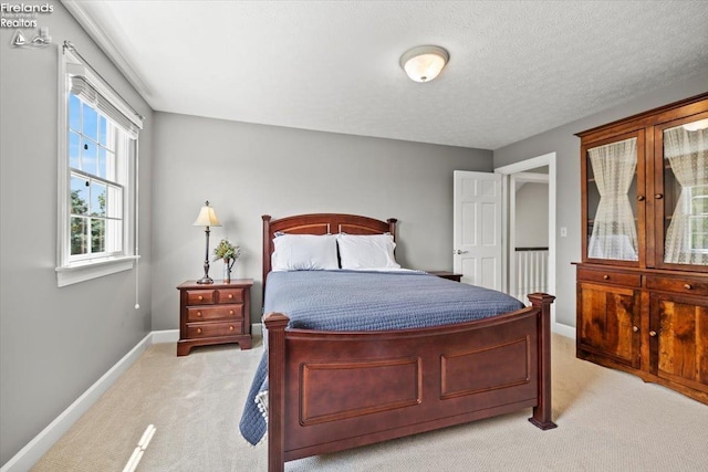 bedroom with light carpet and a textured ceiling