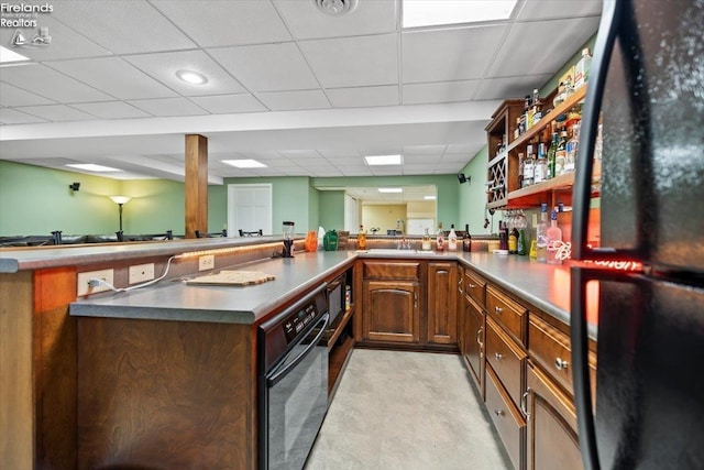 bar featuring a paneled ceiling and black appliances