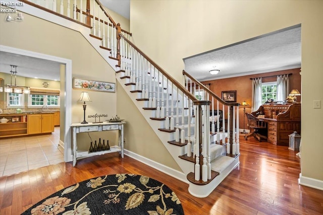 stairs with sink, a textured ceiling, and hardwood / wood-style flooring