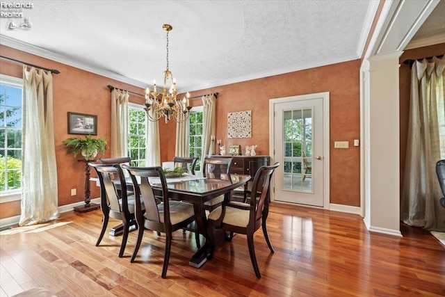 dining room featuring hardwood / wood-style flooring, a notable chandelier, and plenty of natural light