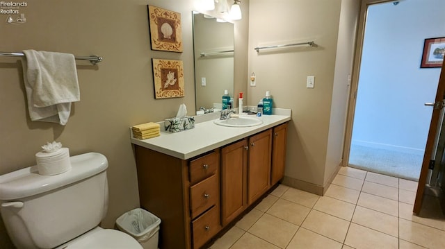 bathroom featuring tile patterned flooring, vanity, and toilet