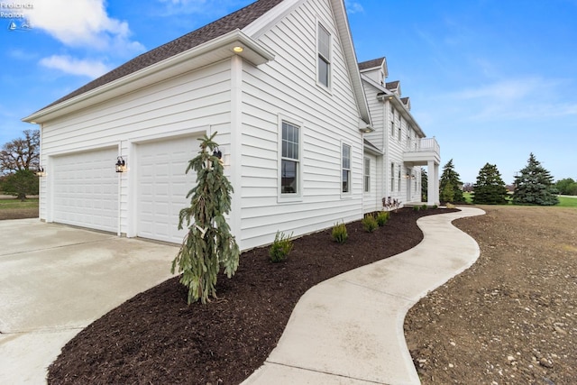 view of side of property featuring a garage and a balcony