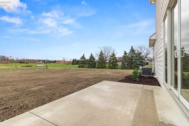 view of yard with central AC unit and a patio area