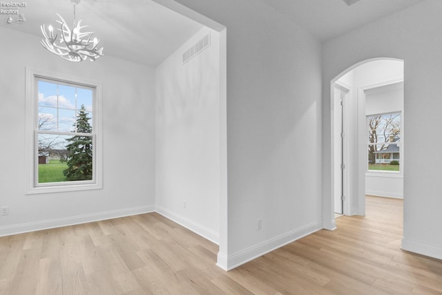 unfurnished room with light hardwood / wood-style floors and a chandelier