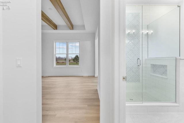 bathroom with beam ceiling, an enclosed shower, and hardwood / wood-style flooring