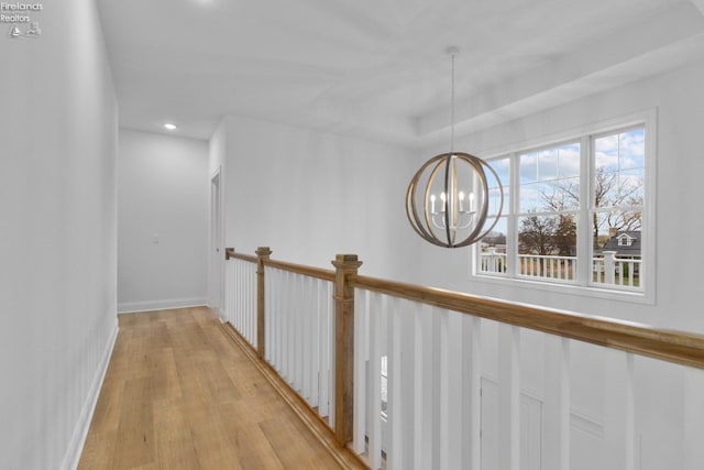 corridor featuring a chandelier and light hardwood / wood-style floors