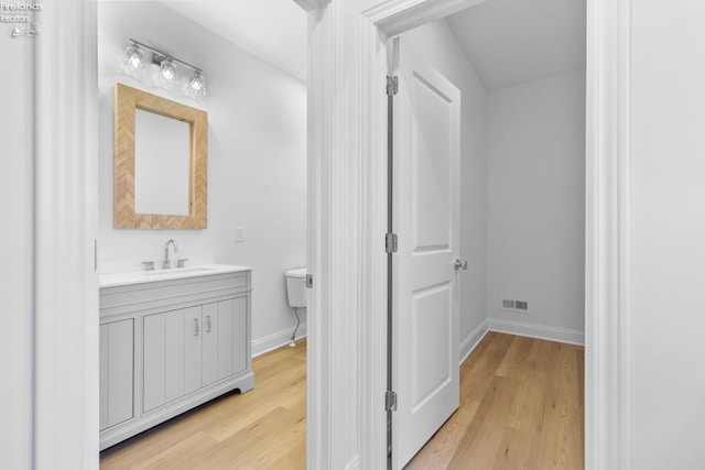 bathroom with hardwood / wood-style floors, vanity, and toilet