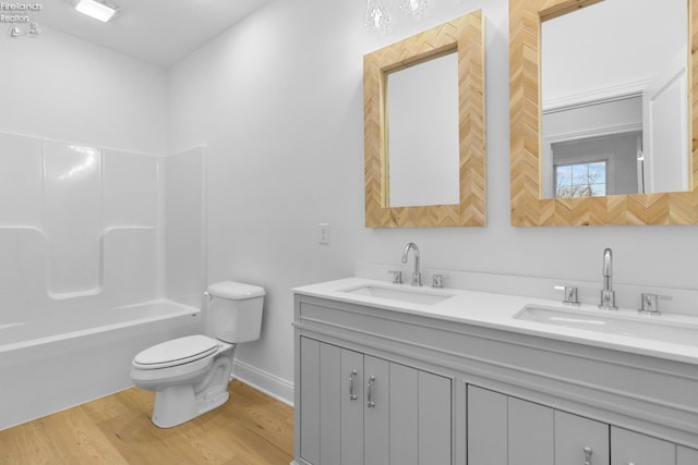 full bathroom featuring hardwood / wood-style flooring, vanity,  shower combination, and toilet