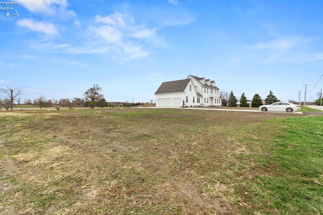 view of yard featuring a rural view and a garage