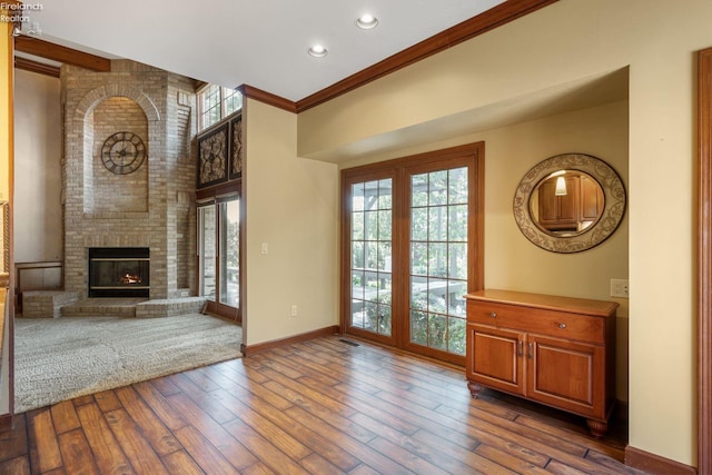 unfurnished living room featuring crown molding, a fireplace, and dark hardwood / wood-style floors