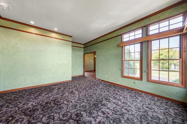 empty room featuring carpet, a textured ceiling, and ornamental molding