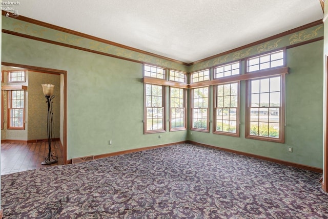 spare room with a textured ceiling and ornamental molding