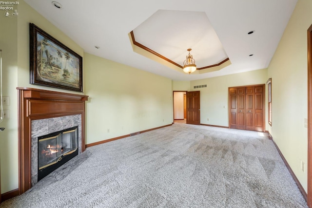 unfurnished living room with light carpet, a tray ceiling, and a premium fireplace