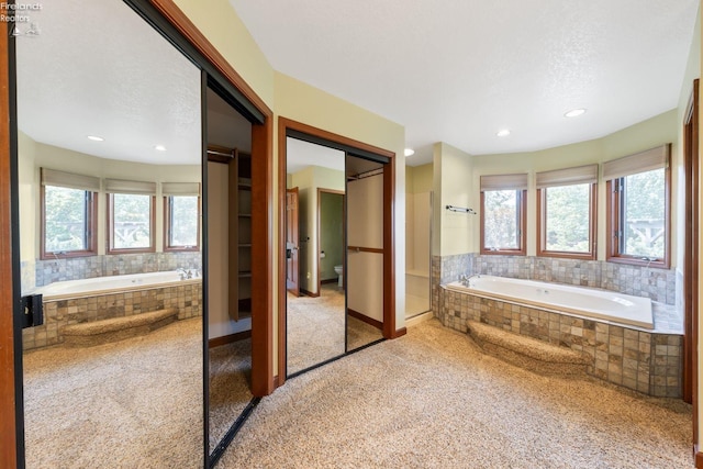 bathroom featuring a relaxing tiled tub