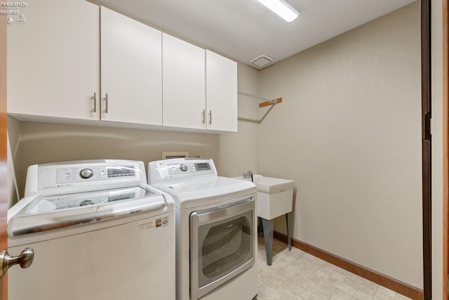 laundry area with cabinets and washer and clothes dryer