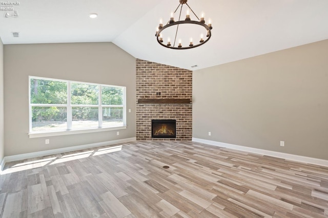 unfurnished living room featuring lofted ceiling, light wood finished floors, a fireplace, and baseboards