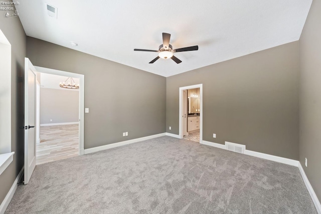 unfurnished bedroom with carpet floors, visible vents, baseboards, and ensuite bathroom