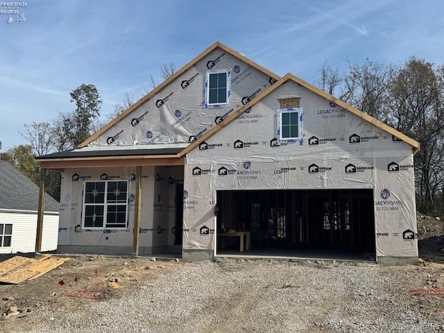 property under construction featuring dirt driveway and a garage